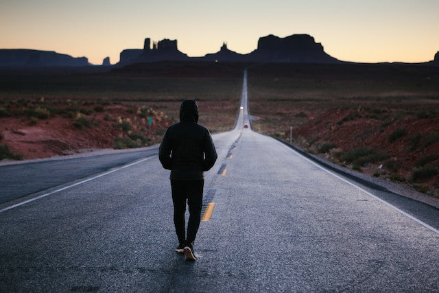 Focused athlete tying running shoes at sunrise, symbolizing commitment and fitness motivation.